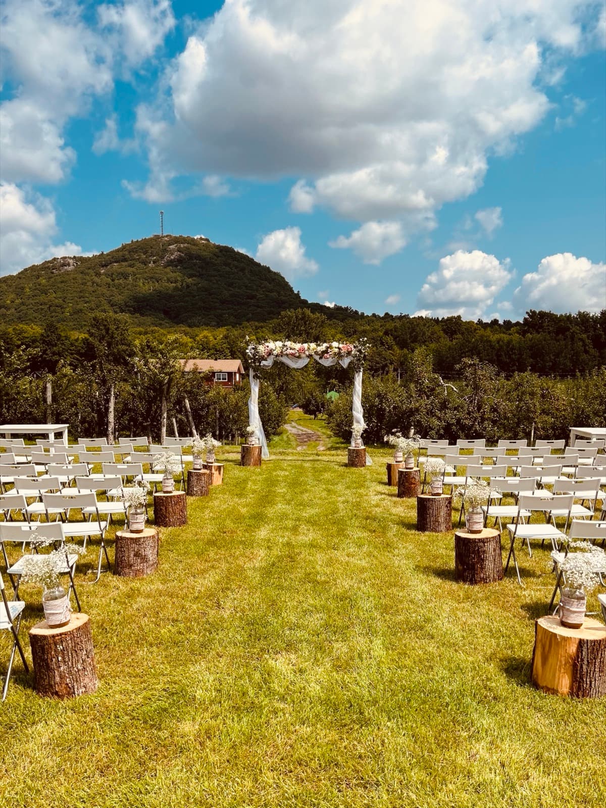 Allée de cérémonie avec chaises et arche fleurie face au Mont-Saint-Grégoire